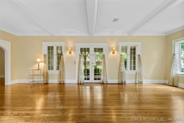 2508 Terwilleger Blvd, Tulsa, OK 74114 - unfurnished living room with french doors, arched walkways, wood finished floors, baseboards, and beam ceiling