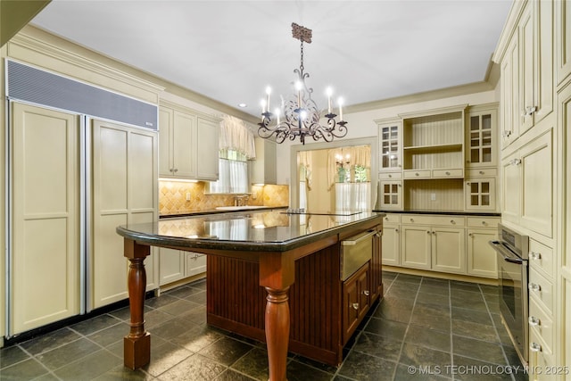 2508 Terwilleger Blvd, Tulsa, OK 74114 - kitchen with paneled built in fridge, dark countertops, a chandelier, and cream cabinets