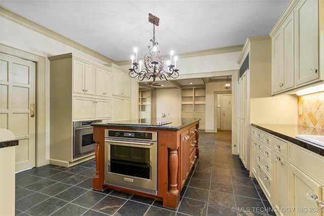 2508 Terwilleger Blvd, Tulsa, OK 74114 - kitchen with oven, cream cabinetry, dark countertops, a chandelier, and crown molding