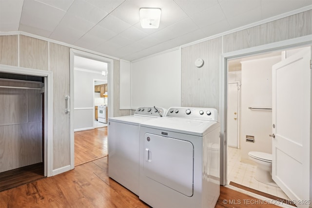 6315 E 5th Pl, Tulsa, OK 74112 - washroom with crown molding, washing machine and dryer, light wood-style floors, and baseboards