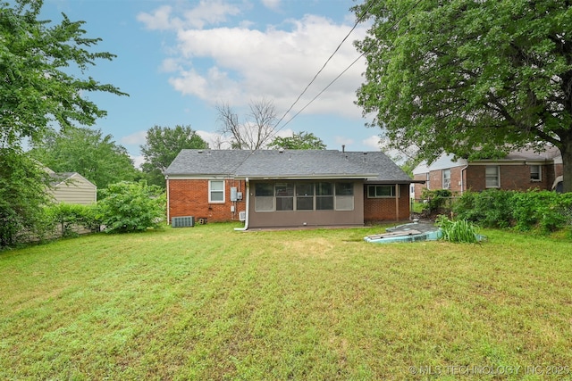 6315 E 5th Pl, Tulsa, OK 74112 - back of house with brick siding, a yard, a sunroom, and central AC