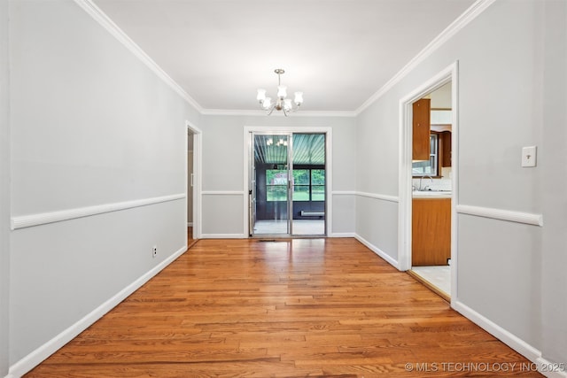 6315 E 5th Pl, Tulsa, OK 74112 - unfurnished dining area with a chandelier, light wood-type flooring, crown molding, baseboards, and a sink