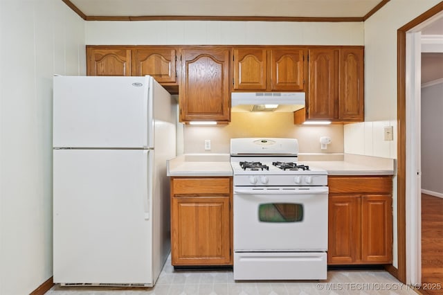 6315 E 5th Pl, Tulsa, OK 74112 - kitchen with white appliances, under cabinet range hood, ornamental molding, light countertops, and brown cabinets