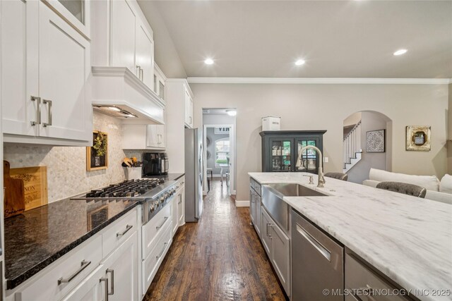 10350 E 122nd St S, Bixby, OK 74008 - kitchen with a sink, stainless steel appliances, dark stone counters, arched walkways, and recessed lighting