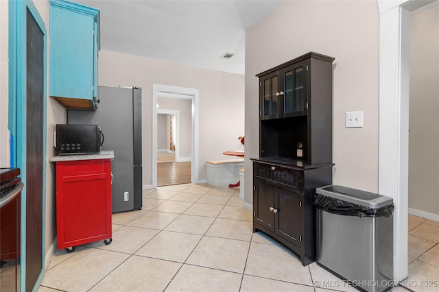 700 D St NW, Ardmore, OK 73401 - kitchen with light tile patterned floors, black microwave, light countertops, and range