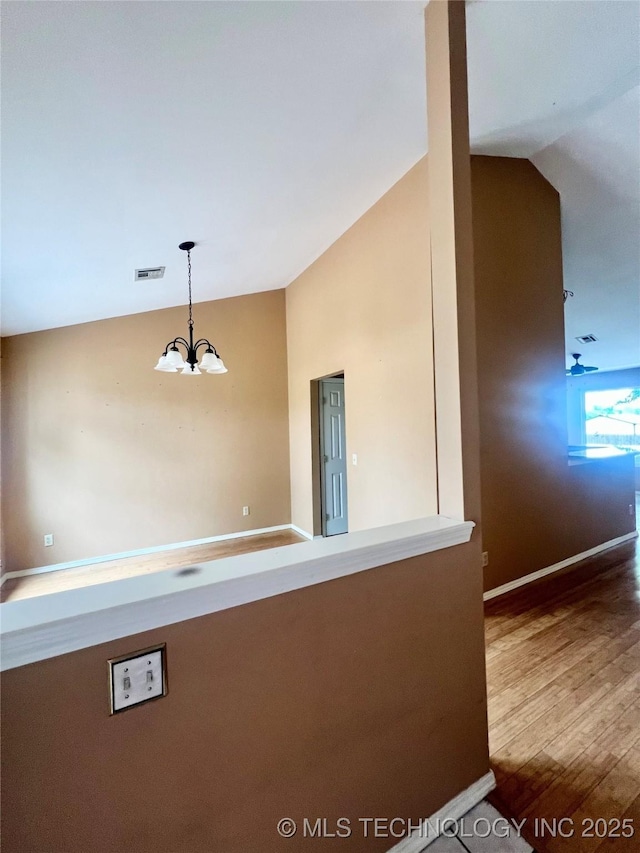 915 Aspenwood St, Cleveland, OK 74020 - corridor featuring lofted ceiling, a chandelier, wood finished floors, and baseboards