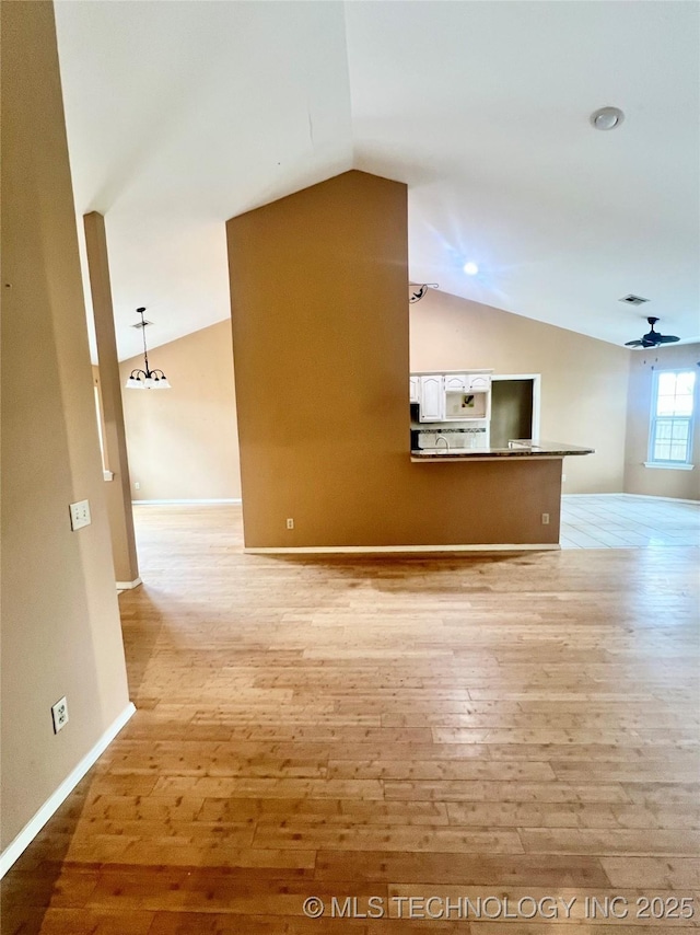 915 Aspenwood St, Cleveland, OK 74020 - unfurnished living room featuring vaulted ceiling, light wood-type flooring, ceiling fan, and baseboards