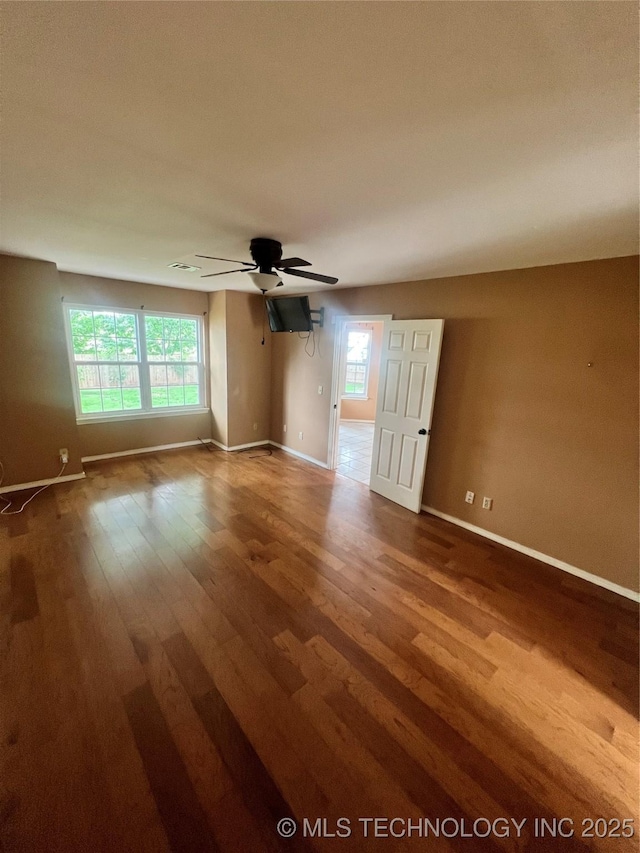 915 Aspenwood St, Cleveland, OK 74020 - unfurnished room featuring wood finished floors, a ceiling fan, baseboards, and healthy amount of natural light