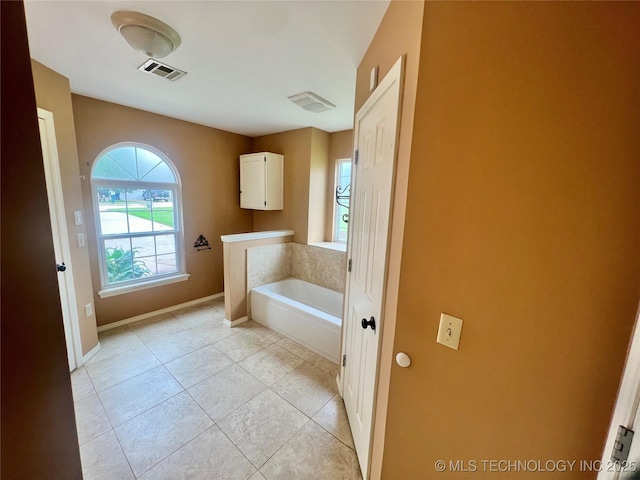 915 Aspenwood St, Cleveland, OK 74020 - full bathroom with a garden tub, baseboards, and tile patterned flooring