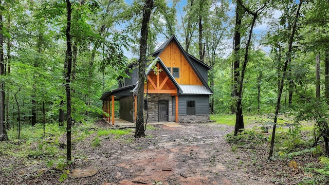 4396 E Cheadle Rd, Milburn, OK 73450 - view of front of house featuring stone siding and a wooded view