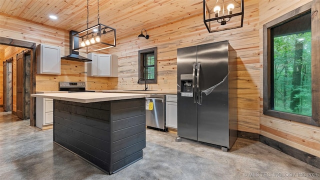 4396 E Cheadle Rd, Milburn, OK 73450 - kitchen featuring stainless steel appliances, wood walls, concrete floors, wall chimney exhaust hood, and a chandelier