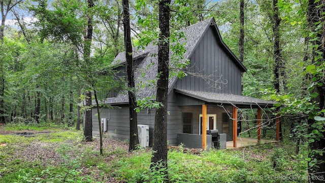 4396 E Cheadle Rd, Milburn, OK 73450 - view of side of home featuring board and batten siding and roof with shingles