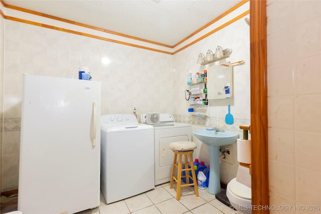 200 S K St, Quinton, OK 74561 - washroom featuring tile walls, independent washer and dryer, light tile patterned floors, a textured ceiling, and ornamental molding