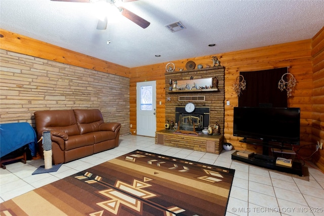 200 S K St, Quinton, OK 74561 - tiled living room featuring a ceiling fan, a textured ceiling, and a fireplace