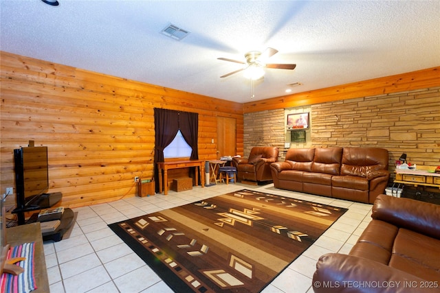 200 S K St, Quinton, OK 74561 - living area featuring tile patterned floors, a ceiling fan, a textured ceiling, and rustic walls