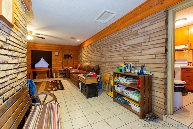 200 S K St, Quinton, OK 74561 - living room with light tile patterned flooring, a ceiling fan, a textured ceiling, and wooden walls
