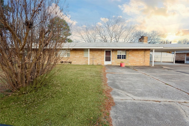 200 S K St, Quinton, OK 74561 - view of front facade with a chimney, a carport, driveway, metal roof, and a front lawn