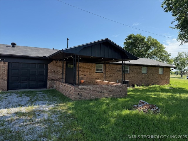 1950 Cimmaron, Wilson, OK 73463 - view of front of home featuring an attached garage, a front yard, and brick siding