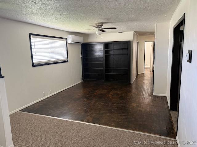 1950 Cimmaron, Wilson, OK 73463 - unfurnished bedroom featuring a wall mounted air conditioner, a textured ceiling, ceiling fan, and wood finished floors