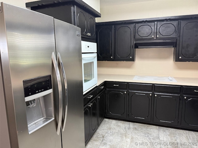 1950 Cimmaron, Wilson, OK 73463 - kitchen featuring white appliances, under cabinet range hood, dark cabinetry, and light countertops
