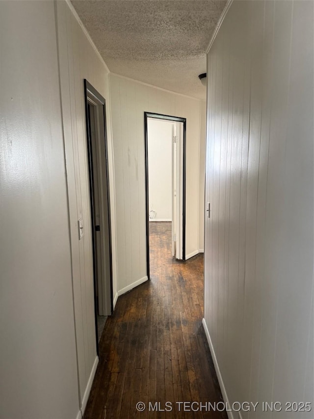 1950 Cimmaron, Wilson, OK 73463 - hall with dark wood-style flooring, a textured ceiling, ornamental molding, and wood walls