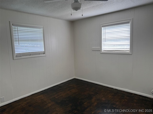 1950 Cimmaron, Wilson, OK 73463 - spare room featuring dark wood-style floors, ceiling fan, and a textured ceiling