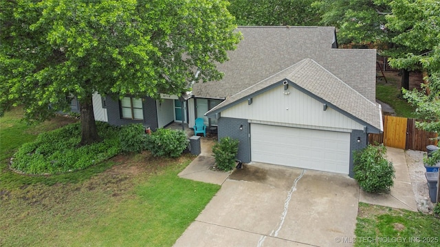 8713 S 77th E Ave, Tulsa, OK 74133 - view of front of house with a shingled roof, brick siding, concrete driveway, and an attached garage