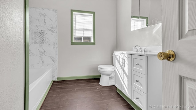 613 NW A St, Ardmore, OK 73401 - bathroom featuring vanity, toilet, wood finished floors, and healthy amount of natural light