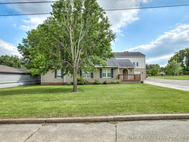 5504 E 5th Pl, Tulsa, OK 74112 - view of front facade with concrete driveway, a front lawn, and a shingled roof