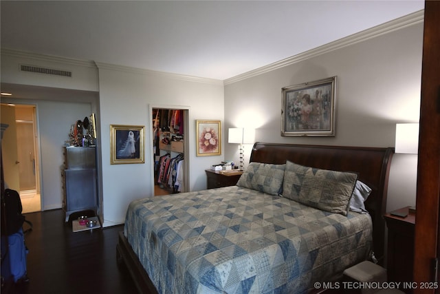 2300 Riverside Dr Unit 5E, Tulsa, OK 74114 - bedroom featuring ornamental molding, a walk in closet, wood finished floors, and a closet