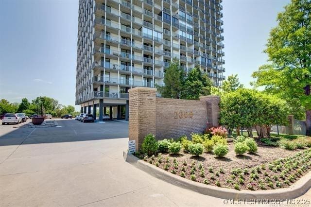 2300 Riverside Dr Unit 5E, Tulsa, OK 74114 - view of apartment building / complex featuring uncovered parking