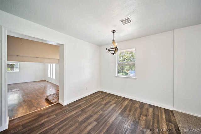 5963 S Westwood Ave, Oilton, OK 74052 - empty room with dark wood-style floors, a chandelier, plenty of natural light, baseboards, and a textured ceiling