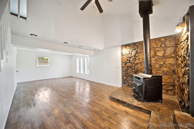 5963 S Westwood Ave, Oilton, OK 74052 - unfurnished living room with a ceiling fan, wood finished floors, a wood stove, and a towering ceiling