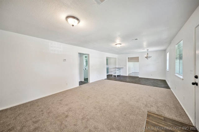 5963 S Westwood Ave, Oilton, OK 74052 - unfurnished living room with dark carpet, a chandelier, baseboards, and dark wood-type flooring