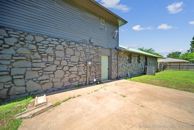 5963 S Westwood Ave, Oilton, OK 74052 - view of property exterior with stone siding, central AC unit, and a patio