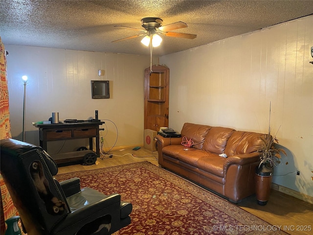 205 N Ash St, Bristow, OK 74010 - living room featuring wood finished floors, a ceiling fan, and a textured ceiling