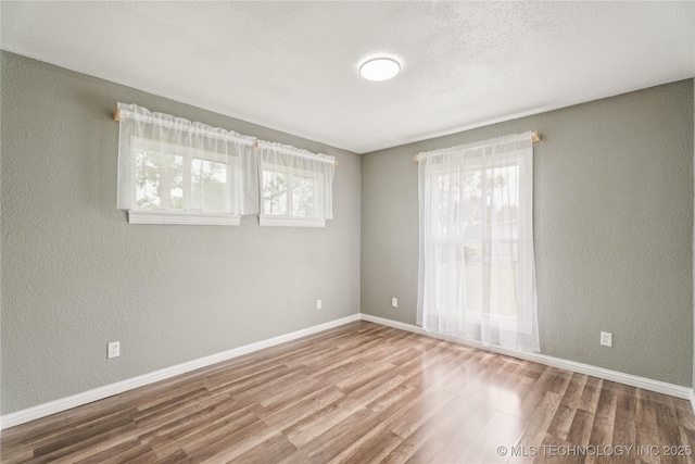 507 S Oklahoma Ave, Haskell, OK 74436 - spare room with wood finished floors, baseboards, and a textured wall