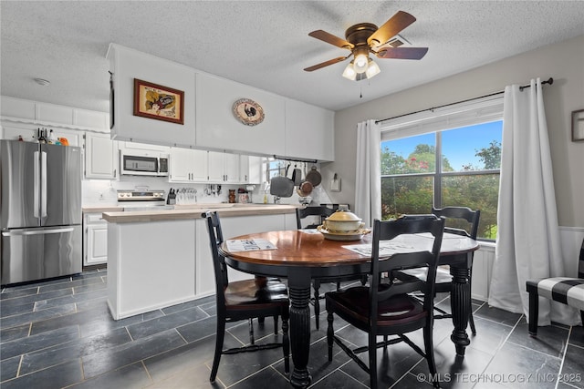 200 Turkey Creek Rd, Bartlesville, OK 74006 - dining room featuring ceiling fan, a textured ceiling, and dark tile patterned floors