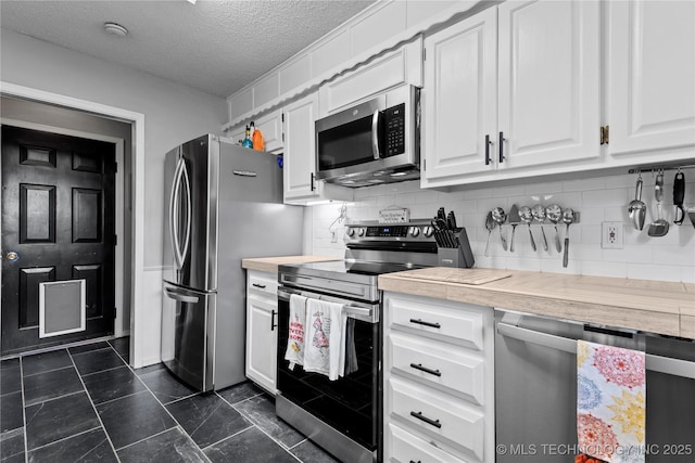 200 Turkey Creek Rd, Bartlesville, OK 74006 - kitchen with appliances with stainless steel finishes, light countertops, white cabinetry, decorative backsplash, and a textured ceiling