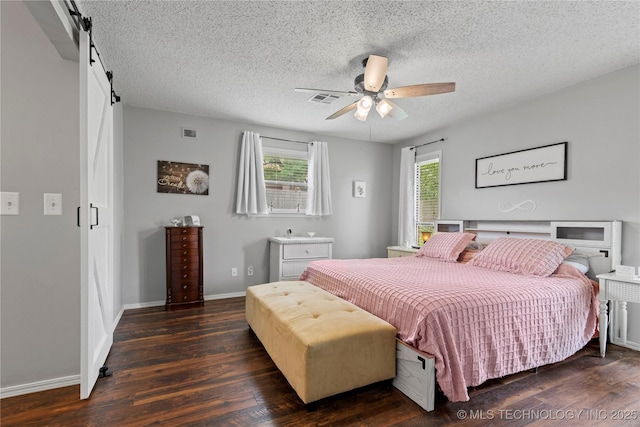 200 Turkey Creek Rd, Bartlesville, OK 74006 - bedroom with wood finished floors, a textured ceiling, baseboards, ceiling fan, and a barn door