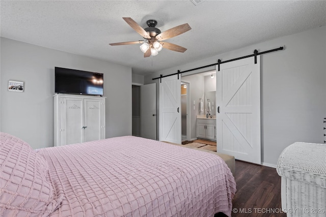 200 Turkey Creek Rd, Bartlesville, OK 74006 - bedroom with a barn door, wood finished floors, baseboards, ensuite bathroom, and a ceiling fan