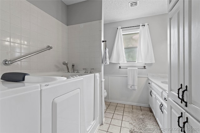200 Turkey Creek Rd, Bartlesville, OK 74006 - bathroom with a garden tub, tile patterned floors, a textured ceiling, vanity, and toilet