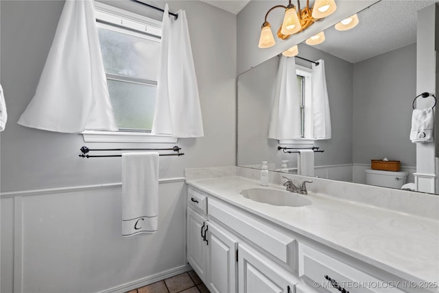 200 Turkey Creek Rd, Bartlesville, OK 74006 - bathroom with healthy amount of natural light, vanity, toilet, a textured ceiling, and tile patterned floors