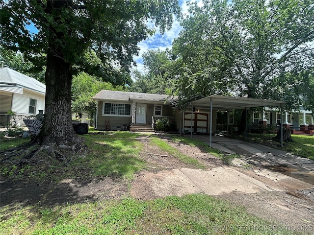 1224 N F St, Muskogee, OK 74403 - view of front facade with concrete driveway, a carport, and an attached garage