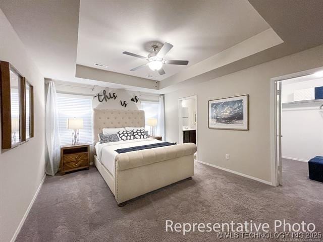 8508 E Queens St, Broken Arrow, OK 74014 - carpeted bedroom featuring a tray ceiling, baseboards, ceiling fan, and ensuite bath