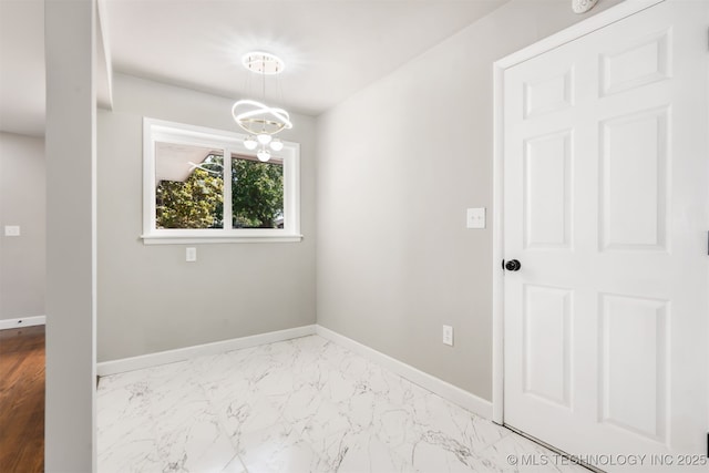 5939 E 26th St, Tulsa, OK 74114 - unfurnished room featuring baseboards, marble finish floors, and a chandelier