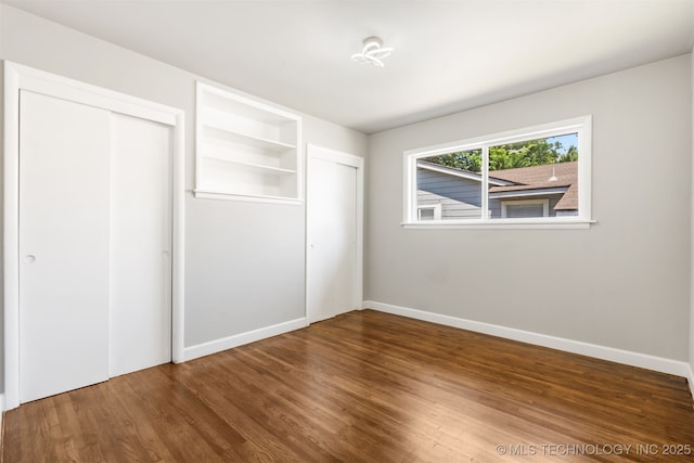 5939 E 26th St, Tulsa, OK 74114 - unfurnished bedroom with multiple closets, wood finished floors, and baseboards