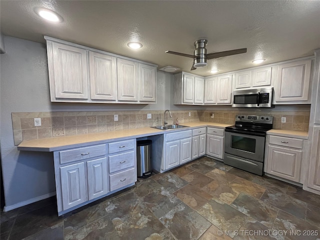 114227 S 4172nd Rd, Checotah, OK 74426 - kitchen featuring stainless steel appliances, a sink, light countertops, tasteful backsplash, and a textured ceiling