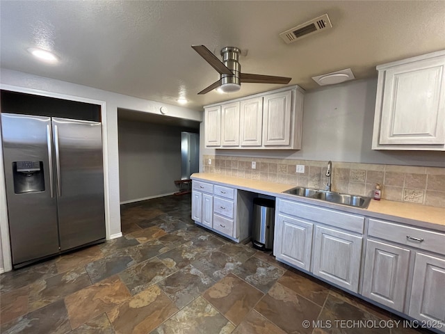 114227 S 4172nd Rd, Checotah, OK 74426 - kitchen with stainless steel refrigerator with ice dispenser, a sink, dark stone finish floors, light countertops, and a ceiling fan