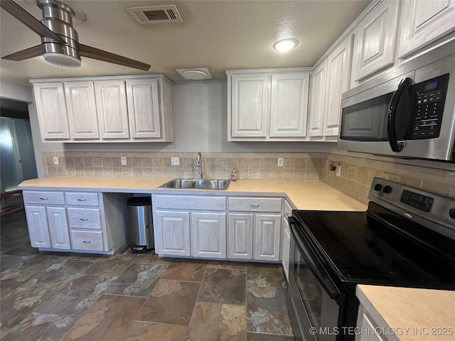 114227 S 4172nd Rd, Checotah, OK 74426 - kitchen with appliances with stainless steel finishes, a sink, white cabinets, and light countertops